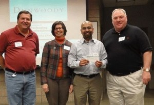 Mike Beck, Karen Conroy, Greg Johnson present check to Stout's Ajay